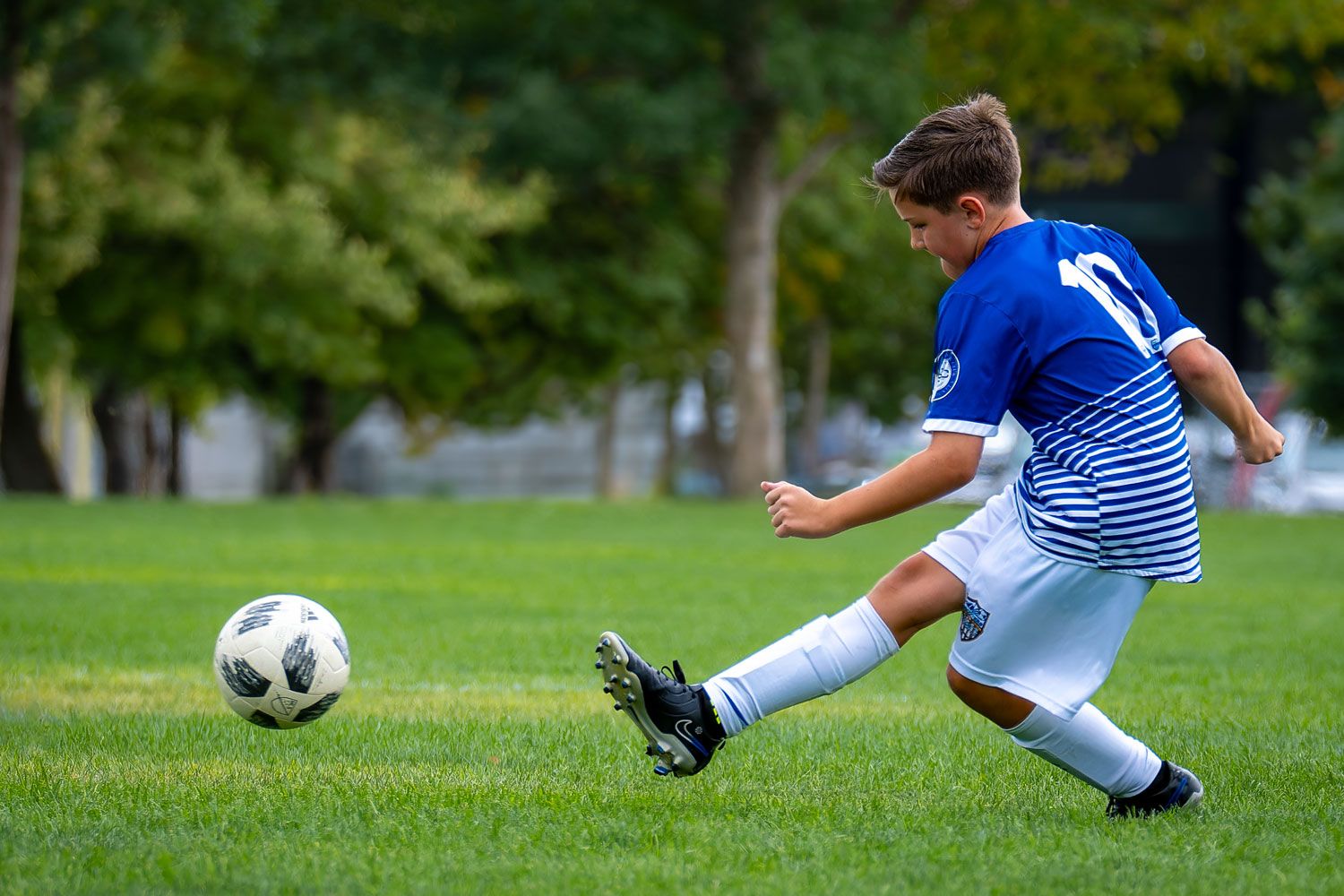 Boy soccer player kicking a ball