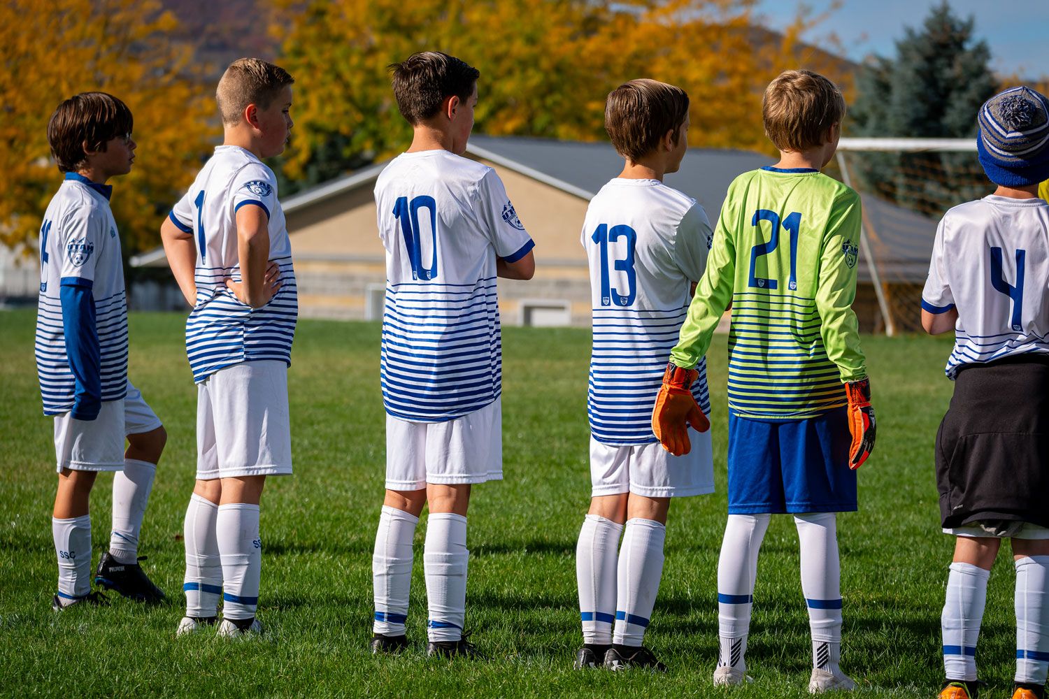 Boys soccer team lined up in a row looking onto the field